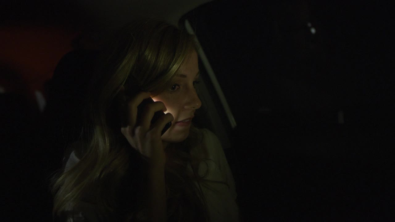 近距离的女人在车在晚上打电话/尼菲，犹他州，美国视频下载