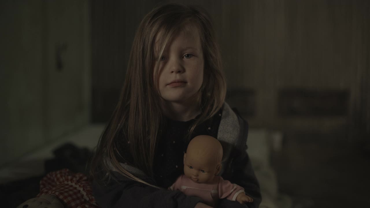 严肃可怜的女孩抱着玩具娃娃的肖像/雪松山，犹他州，美国视频素材