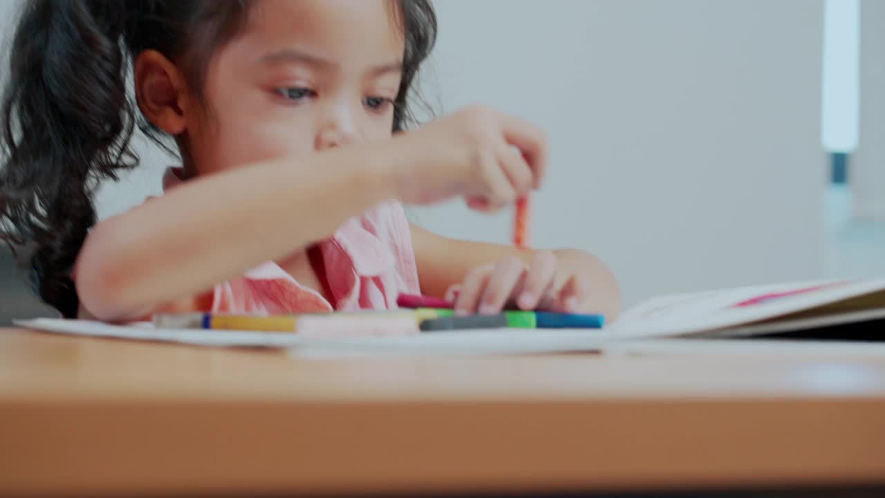 小女孩正在画册上画画和涂色。视频素材