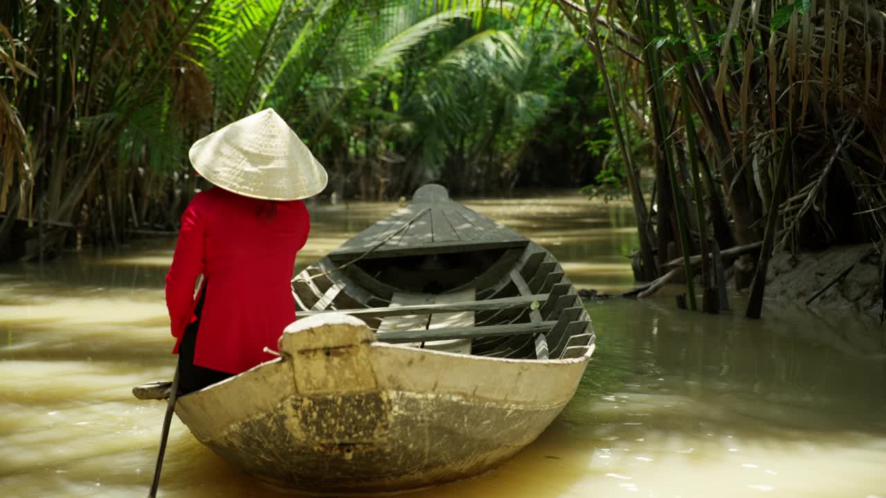 越南女性在传统服饰划船舢板越南视频素材
