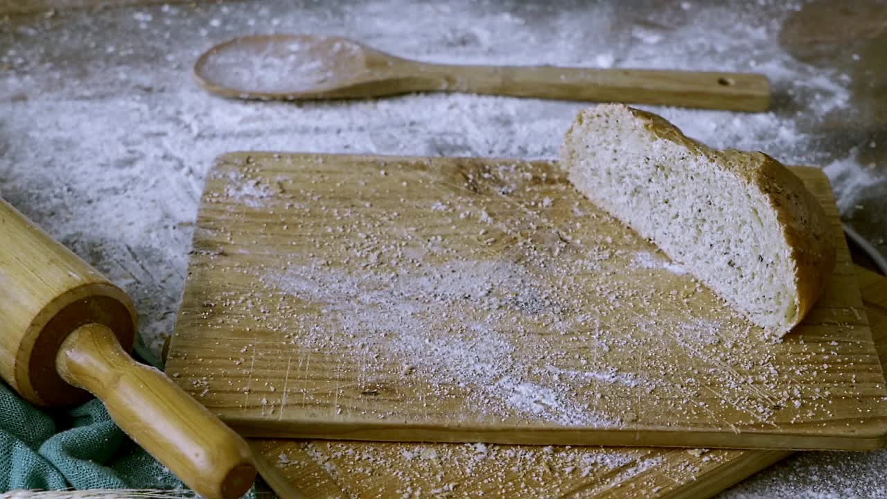 在一个乡村厨房里，乡村酸面包面包落在桌子上的慢镜头视频下载