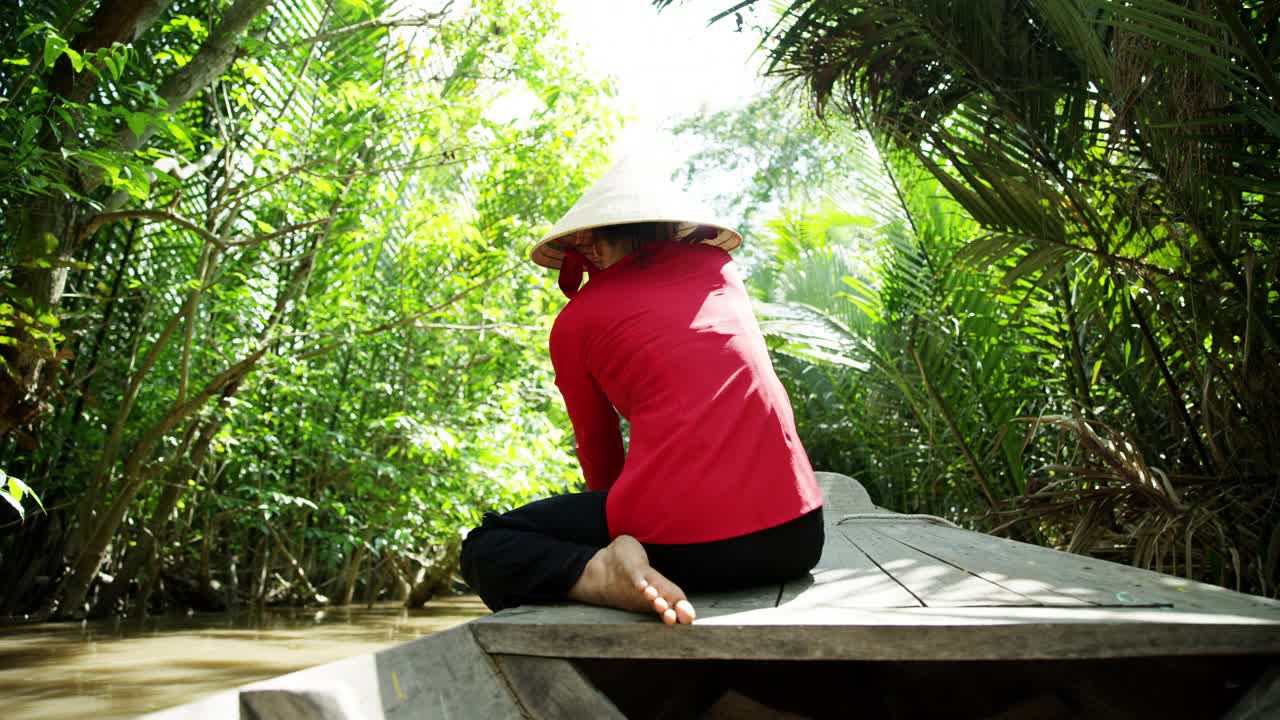 舢板经过越南湄公河沿岸的热带棕榈树视频素材