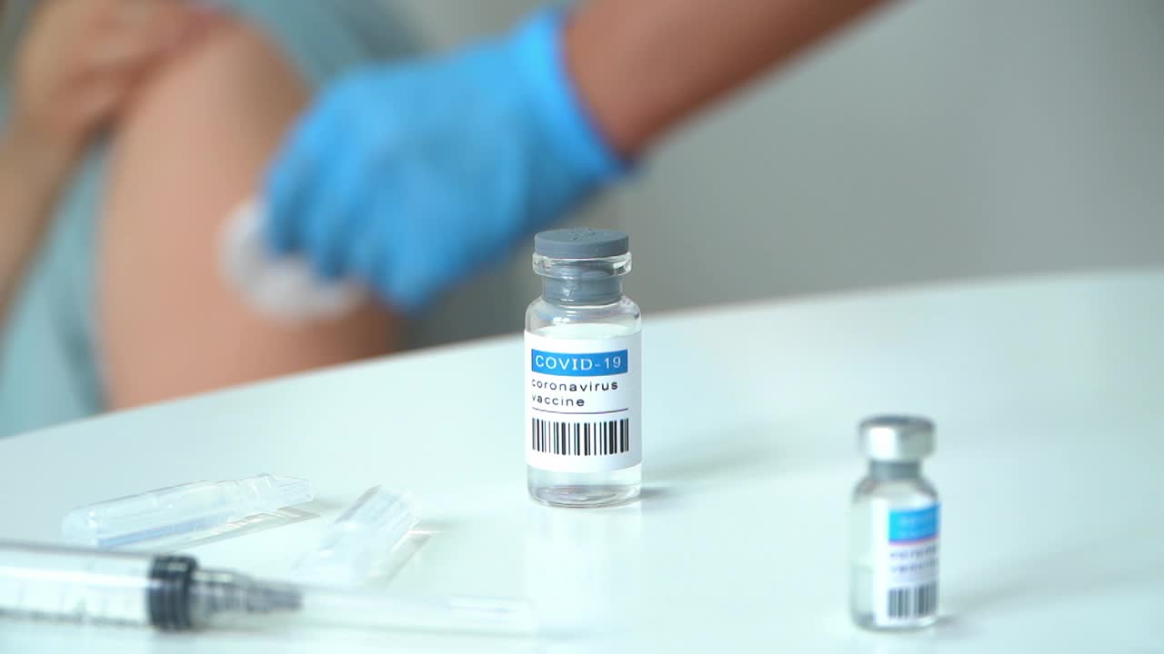Amupla与covid-19疫苗背景护士手戴手套为患者接种疫苗。医生用注射器将药物注射到手上。视频下载