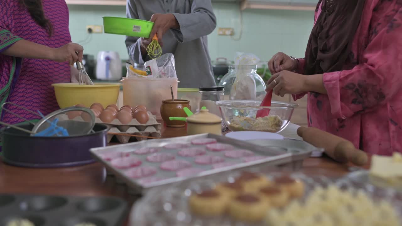 马来西亚马来人兄弟姐妹成年子女帮助母亲在厨房烘焙准备家庭在家里庆祝开斋节视频下载
