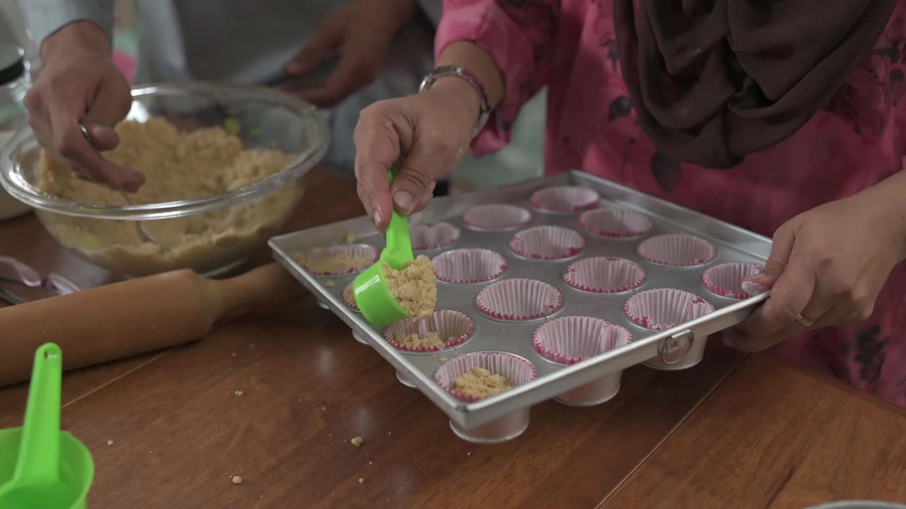 上角马来西亚马来人的兄弟姐妹成年子女帮助母亲在厨房烘焙准备家庭庆祝开斋节视频下载