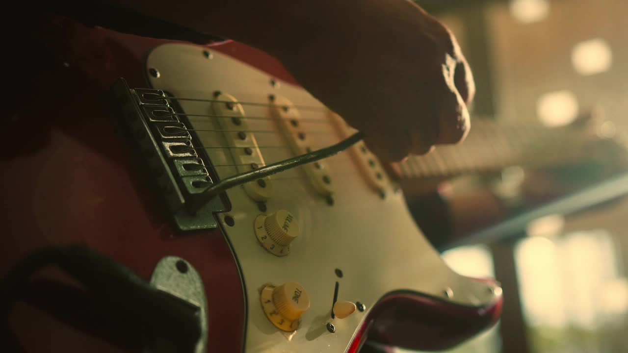近手的音乐家弹奏电吉他的歌曲与音乐与灯光闪耀的背景视频素材