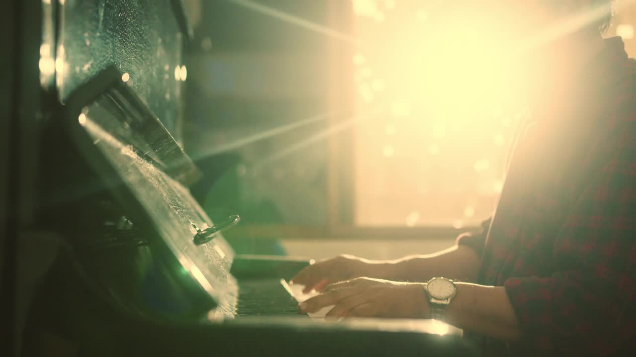 闭合钢琴家的手指按在黑白钢琴键与灯光闪耀的背景视频下载