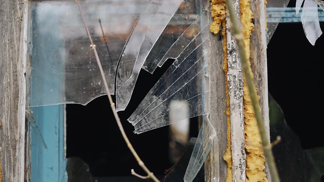 一块石板掉在旧窗户上，砸碎了一块玻璃。慢动作拍摄视频下载