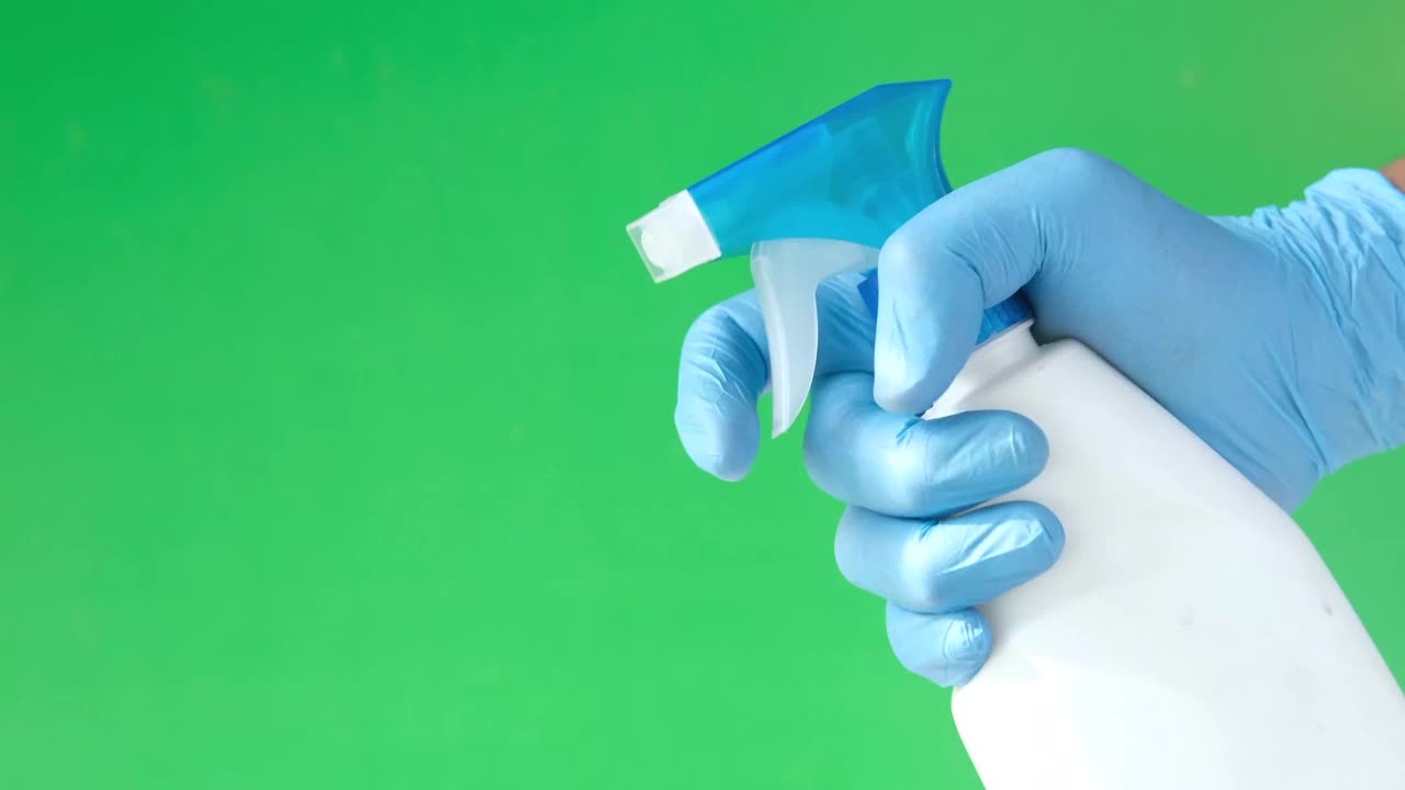 在绿色背景下，手拿蓝色橡胶手套视频下载