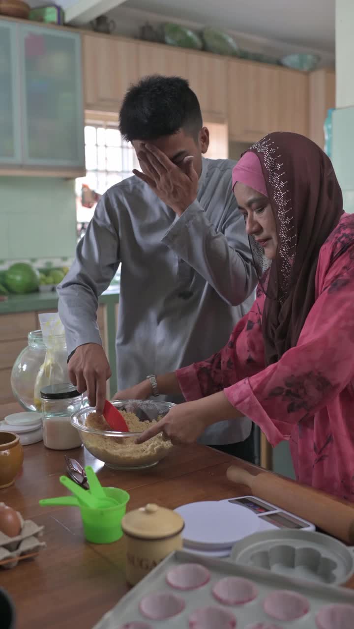 马来西亚马来人儿子成年子女帮助母亲在厨房烘焙准备家庭在家里庆祝开斋节视频下载