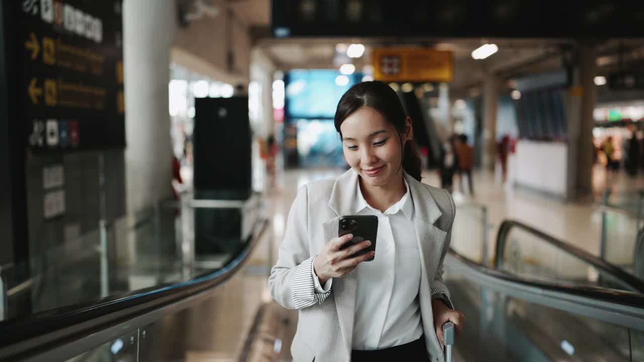 亚洲女性在机场使用智能手机视频素材