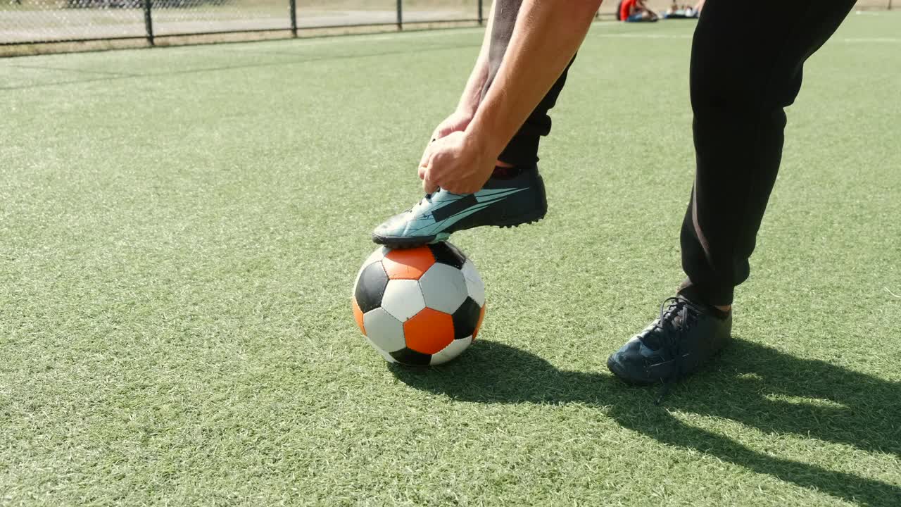 足球运动员穿着靴子在场上系鞋带视频下载