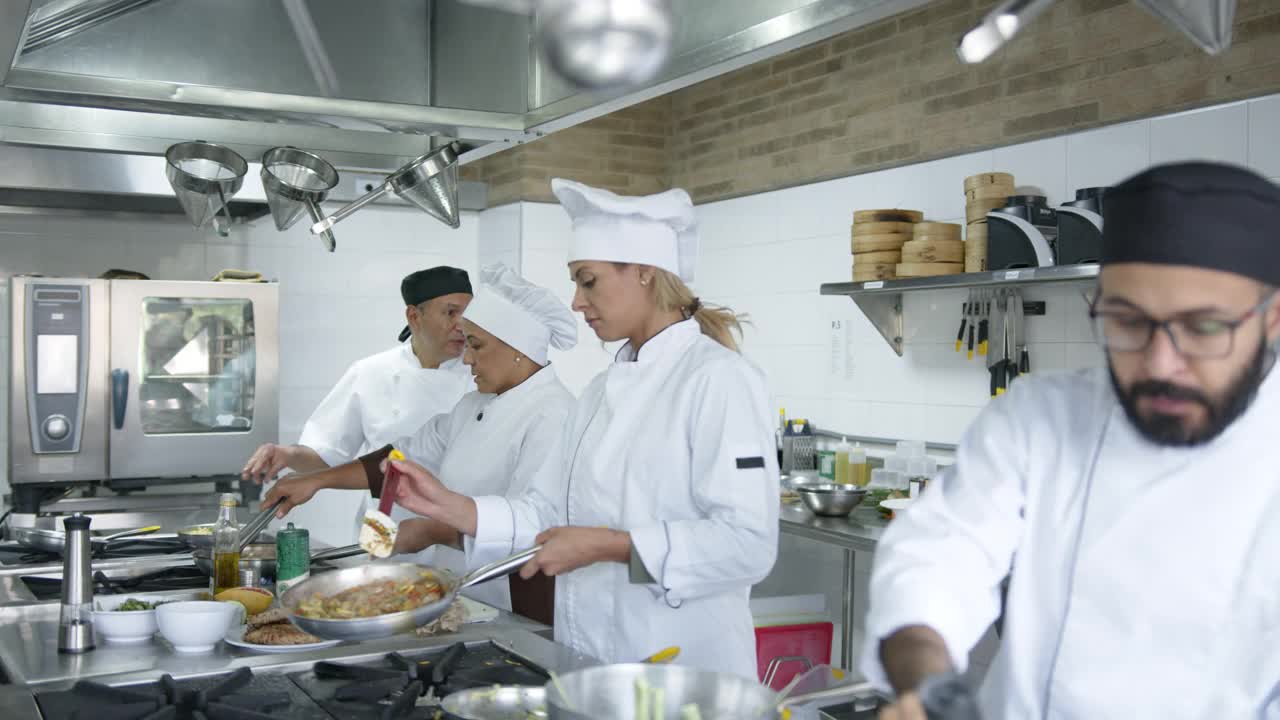 快乐的厨师团队，副厨师和助手一起工作在厨房有说有笑视频素材