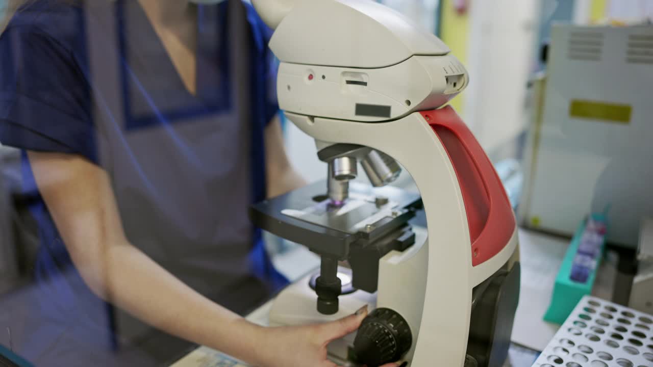 年轻女性医学技术人员使用显微镜视频素材