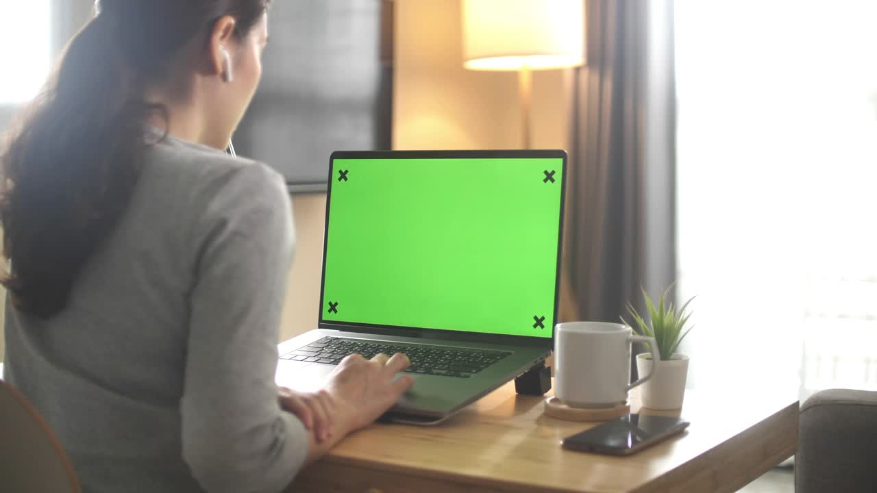 在家里使用绿色屏幕笔记本电脑的妇女视频下载