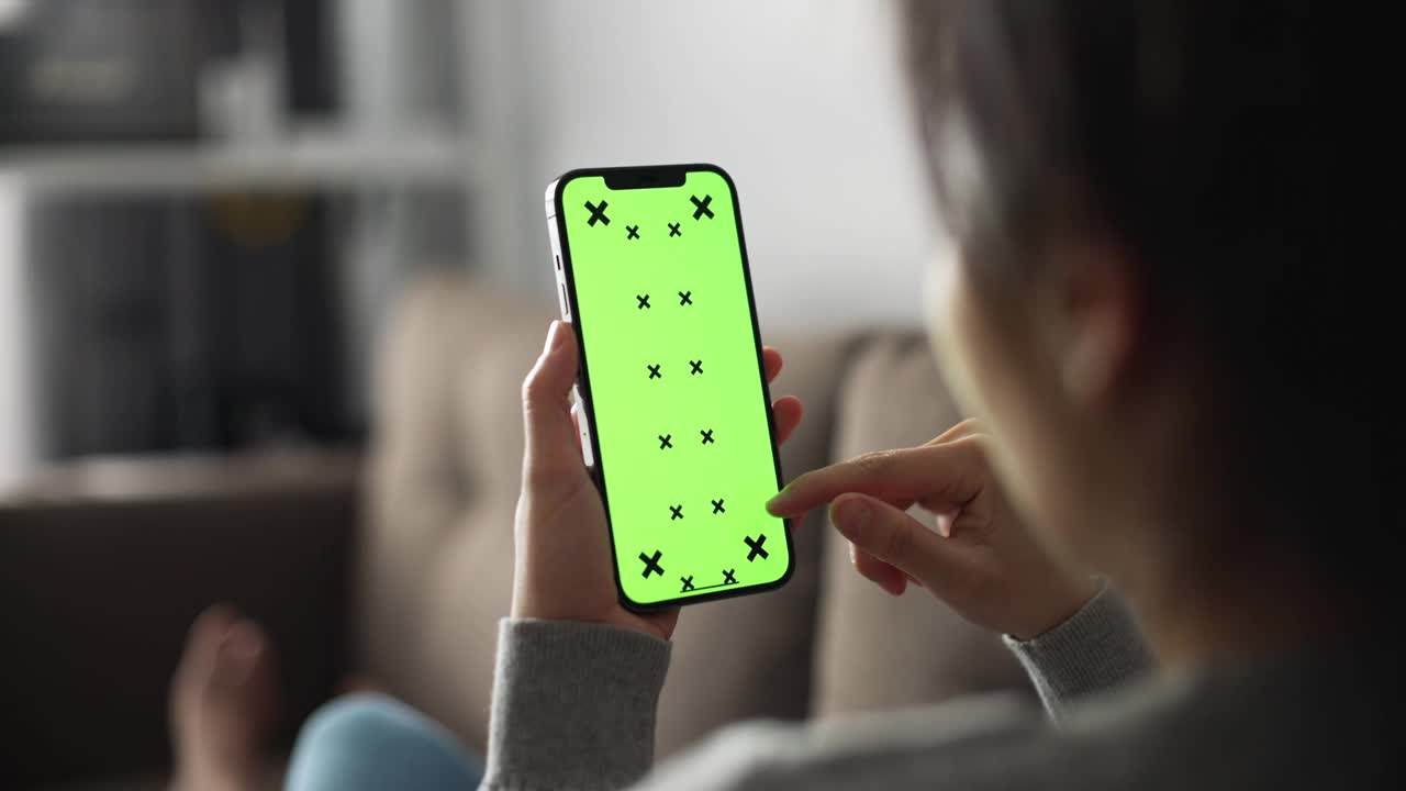 女人在用绿色屏幕的智能手机视频素材