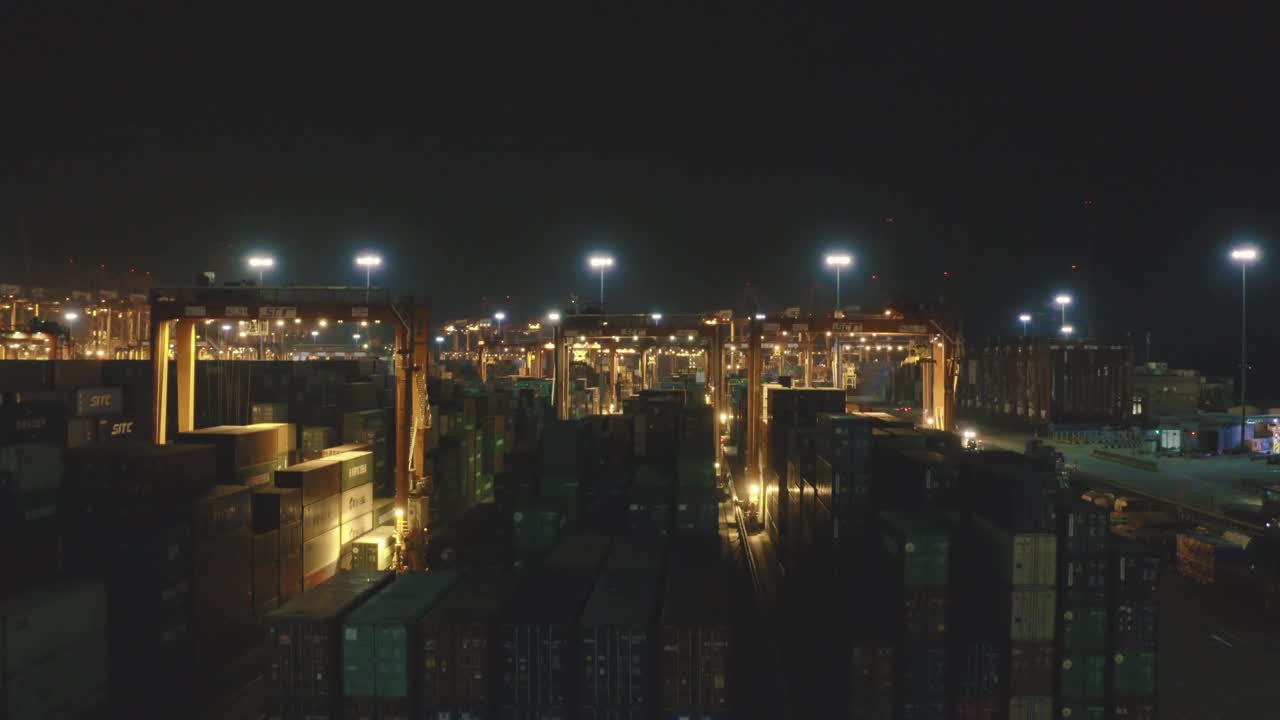 无人机拍摄的繁忙港口的集装箱夜景视频下载