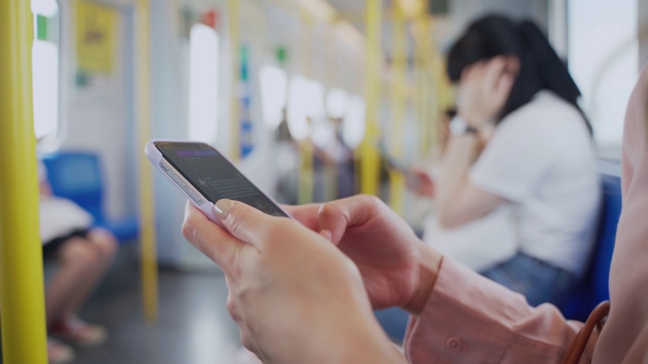 在公共交通工具中使用手机的女性的手靠近视频素材
