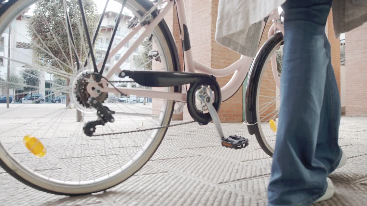 慢动作视频的一个女人走，而她拿着她的自行车-腿和脚的近距离镜头视频下载