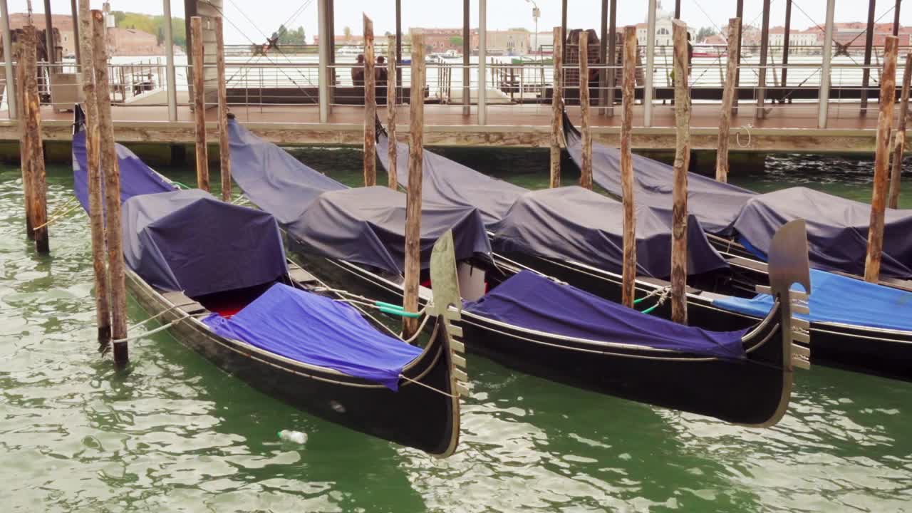 慢镜头中，在阴郁的一天，意大利威尼斯的泻湖碧水中，平底船在波浪上摇摆视频下载