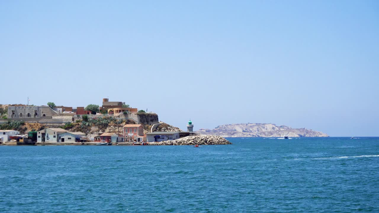阳光明媚的法国马赛老港口附近的地中海。远处有建筑物的土地视频下载