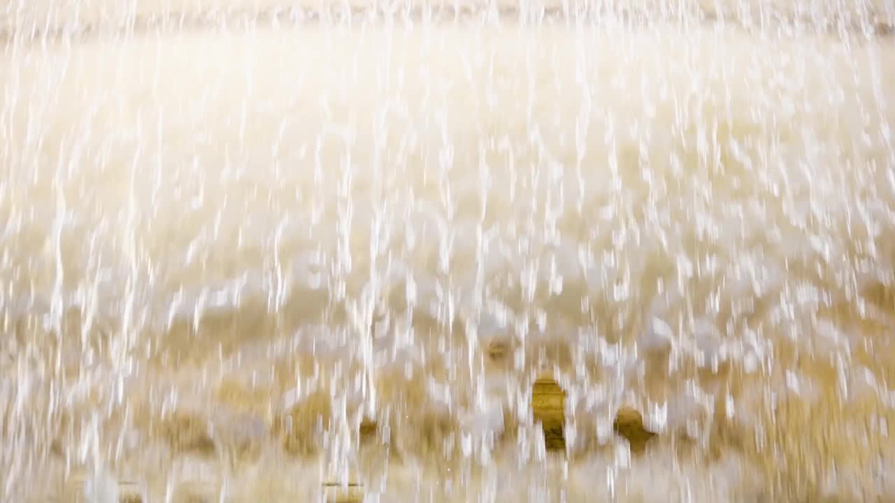 老黄大理石喷泉水幕的特写。透明的水流。夏天阳光灿烂的日子视频下载