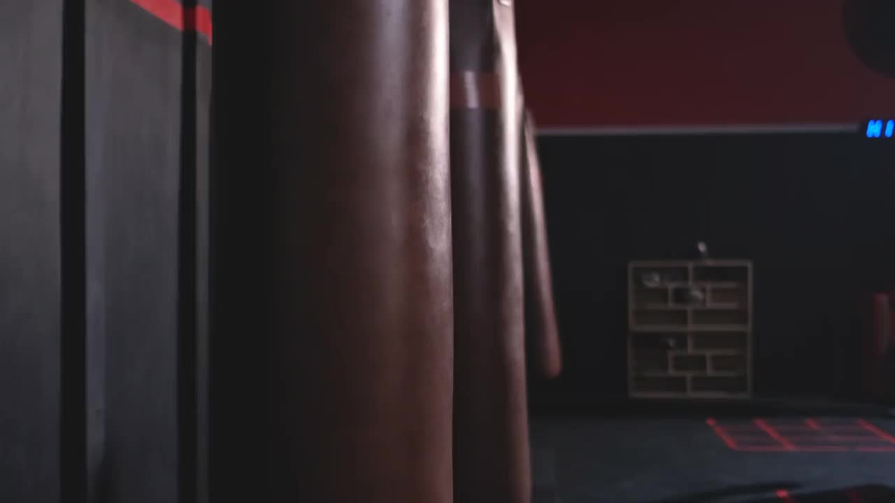 一群人在昏暗的健身房里用沙袋练习拳击视频素材