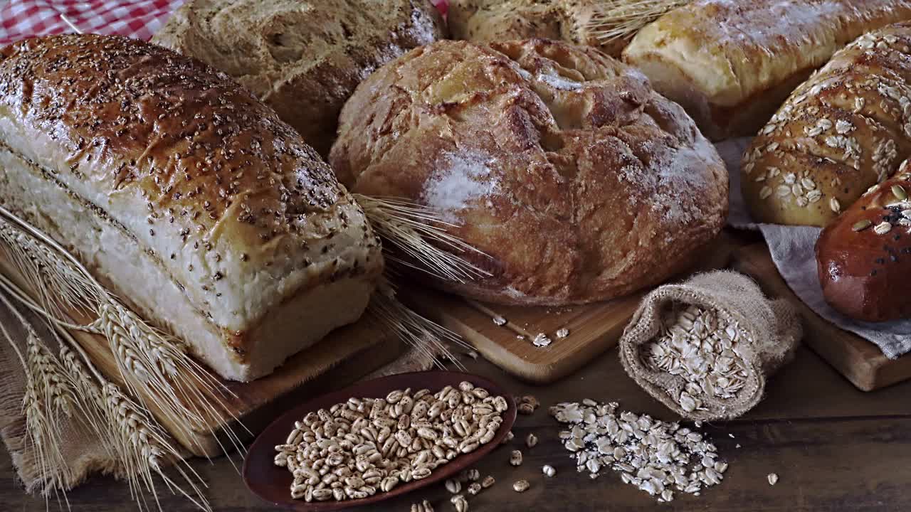 在慢动作中平移一组新鲜的面包和烘焙食品的特写。手工烘焙视频下载