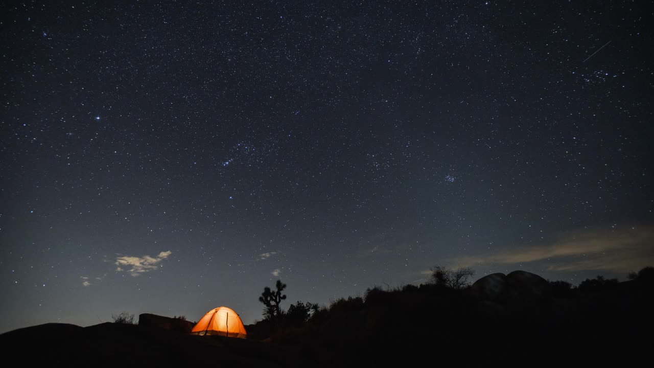在夜晚的星空下在沙漠中露营。视频下载