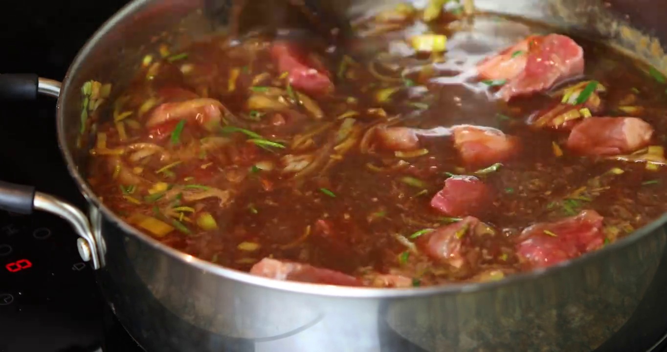 牛肉在一个大的不锈钢烹饪锅中煨炖视频下载