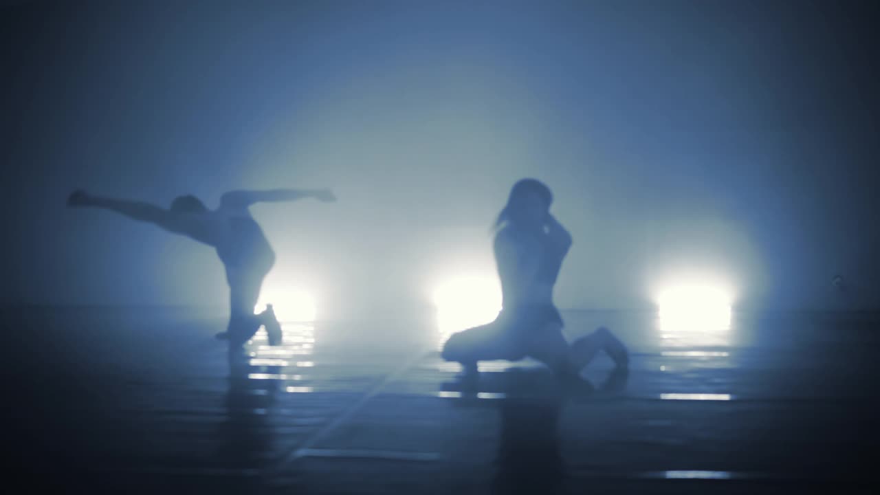 浪漫的专业芭蕾舞组在黑暗的舞台上练习动作，从缓慢的快门速度中产生鬼影效果视频下载