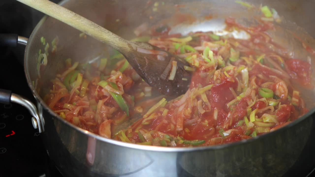在煎韭葱和番茄的锅中加入切碎的迷迭香，然后用木勺搅拌视频下载