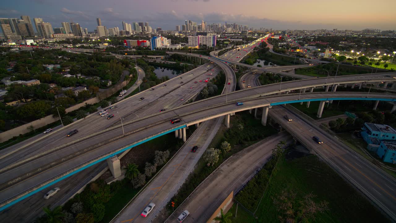 大而繁忙的高架交通枢纽95州际公路和I-195在北迈阿密，与设计区和迈阿密市中心的远景，日落时，用超宽镜头，无人机制作的b-roll镜头与静态摄像机。视频素材