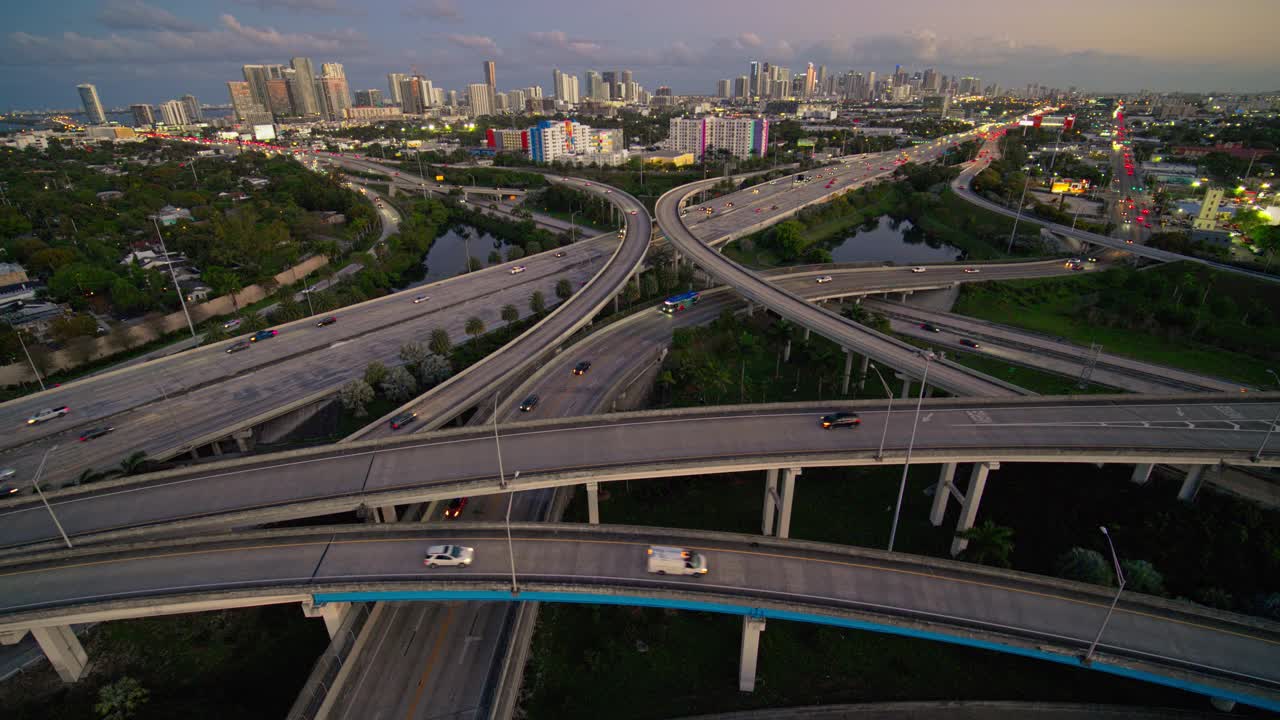 大而繁忙的高架交通枢纽95州际公路和I-195在北迈阿密，与设计区和迈阿密市中心的远景，日落时，用超宽镜头，无人机制作的b-roll镜头与静态摄像机。视频下载