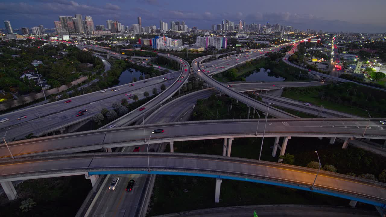 大而繁忙的高架交通枢纽州际95和I-195在北迈阿密，设计区和迈阿密市中心的远程视图，在晚上，用超宽镜头，无人机制作的b-roll镜头与静态摄像机。视频下载