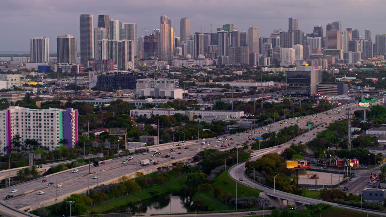 从美国佛罗里达州北迈阿密的高架十字路口，以及繁忙的95号州际公路上眺望迈阿密市区的夜晚。无人机制作的b-roll镜头与电影平移轨道摄像机运动。视频下载