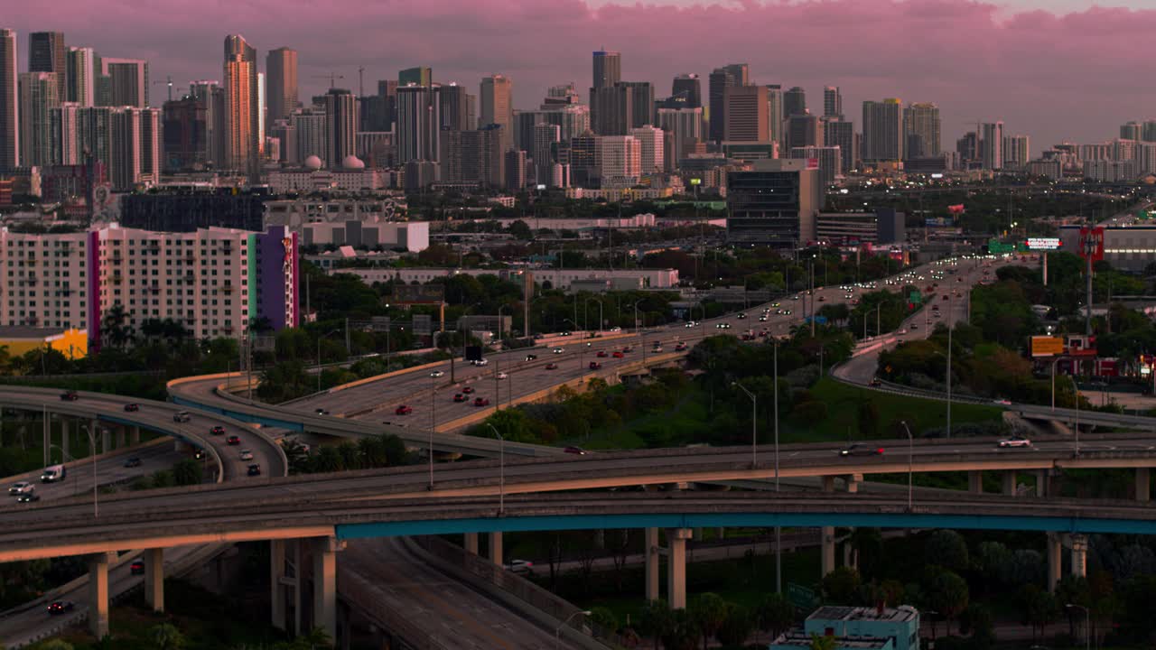 日落时分，从美国佛罗里达州北迈阿密的高架十字路口，以及繁忙的95号州际公路，眺望迈阿密市中心。无人机拍摄的b-roll镜头和静态摄像机。视频下载