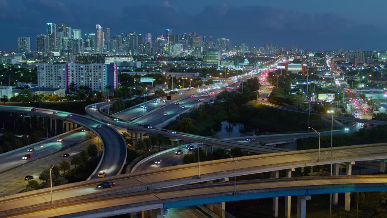 从美国佛罗里达州北迈阿密的高架十字路口，以及繁忙的95号州际公路上眺望迈阿密市区的夜晚。无人机拍摄的b-roll镜头和静态摄像机。视频下载