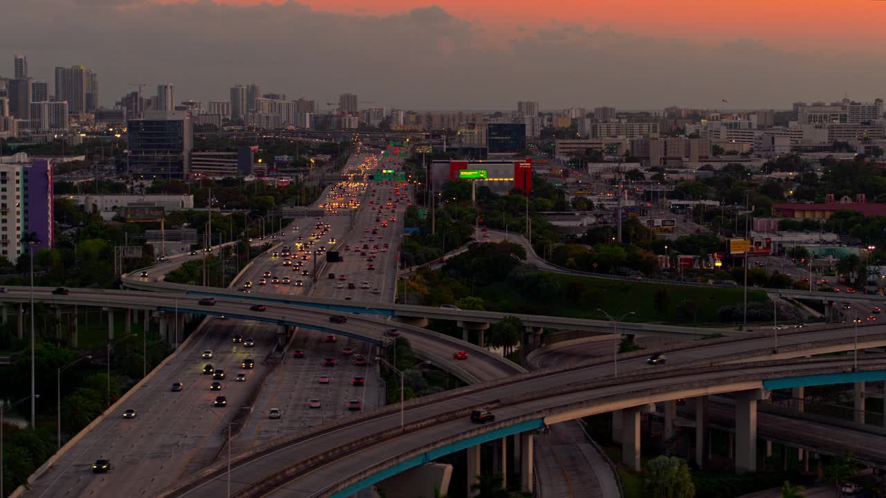 日落时分，从美国佛罗里达州北迈阿密的高架十字路口，以及繁忙的95号州际公路，眺望迈阿密市中心。无人机制作的b-roll镜头与电影宽摇摄轨道摄像机运动。视频下载