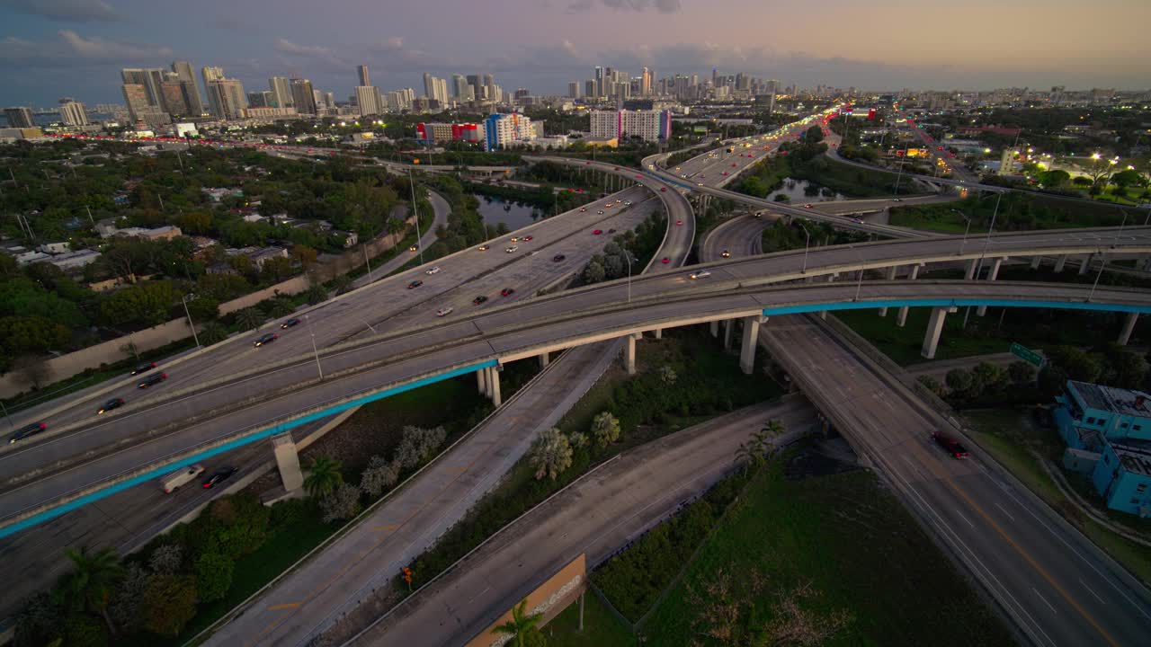 在北迈阿密，95号州际公路和I-195号公路之间繁忙的高架交通枢纽，日落时分，用超宽镜头拍摄的迈阿密市区和设计区远处的景象。无人机拍摄的b-roll镜头和平移摄像机的运动。视频素材