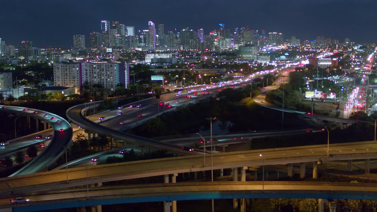 夜间鸟瞰图迈阿密设计区和遥远的迈阿密市中心在大高架路口在北迈阿密，佛罗里达。无人机拍摄的b-roll镜头和平移摄像机的运动。视频下载