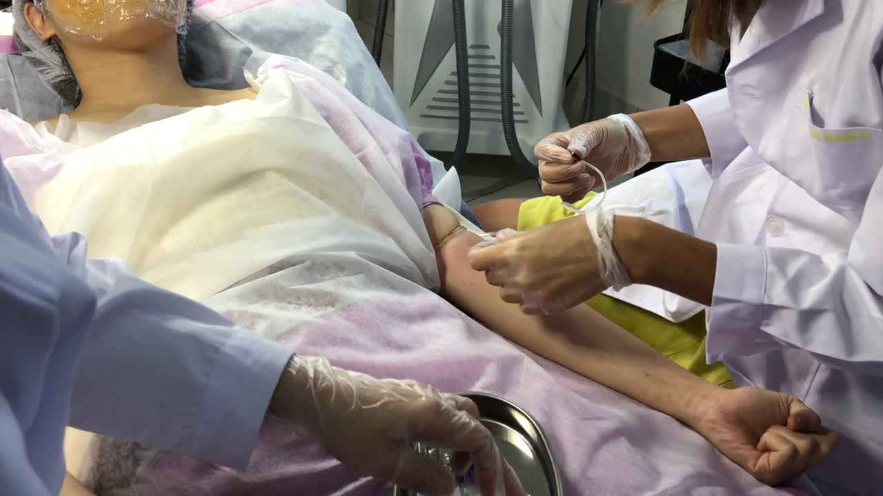 一名亚裔华裔女护士在诊所为一名中国女性患者的手臂静脉采血视频下载