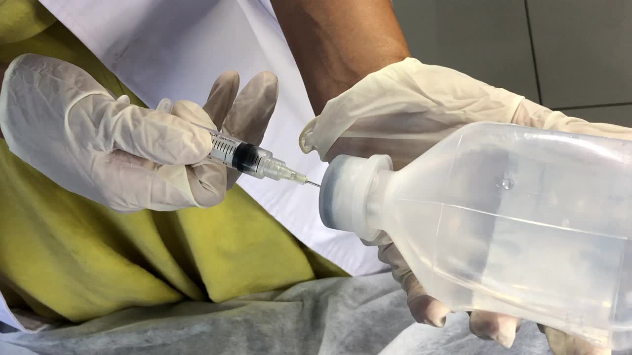 亚裔华裔女护士在临床准备生理盐水注射注射器视频下载