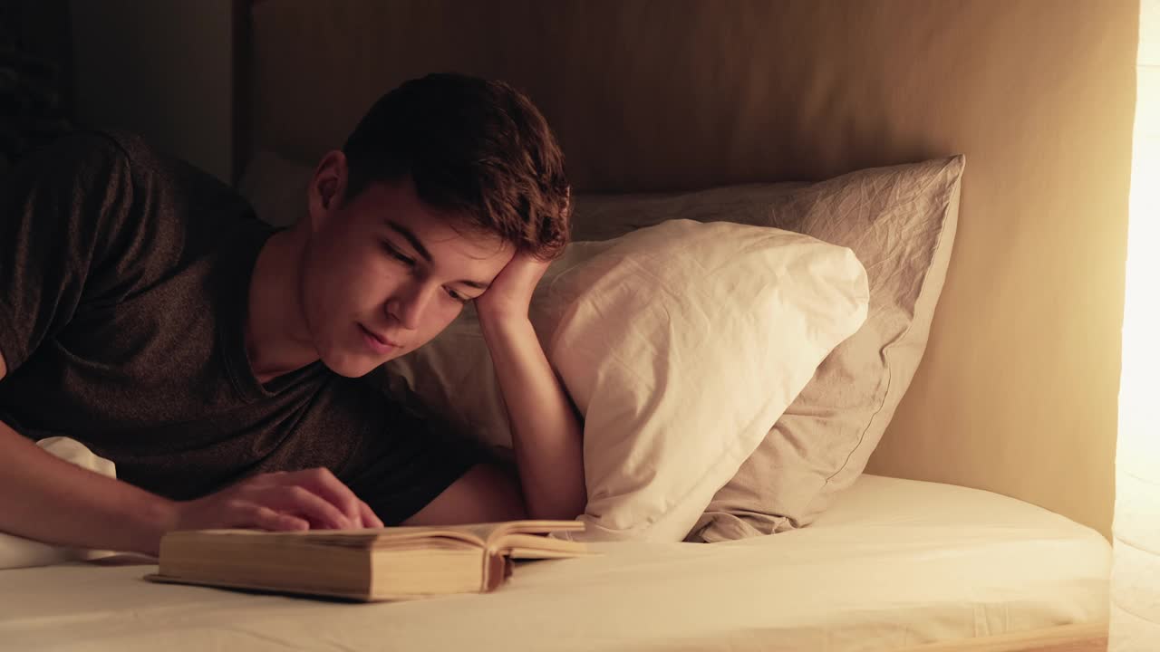 深夜读书，晚上爱好放松的家伙，书舒适的床视频下载
