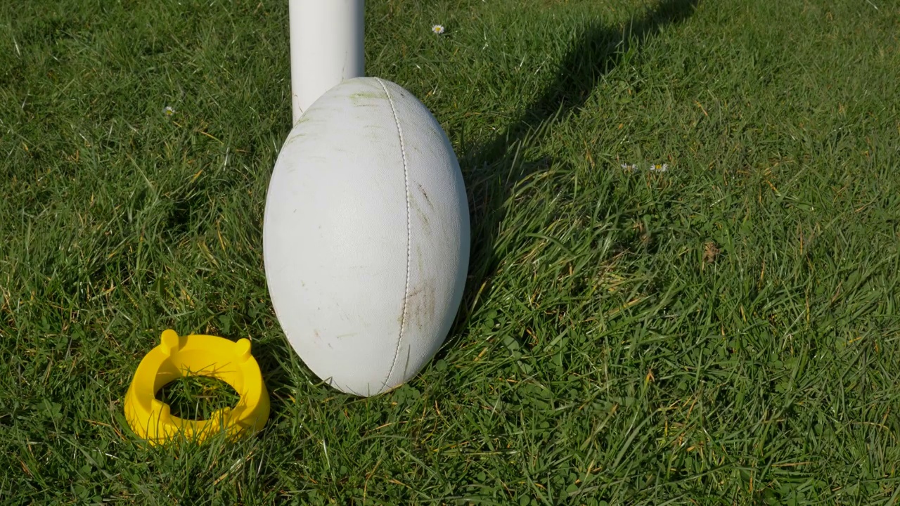 橄榄球球和球座被放置在橄榄球柱旁边的近距离射击视频下载