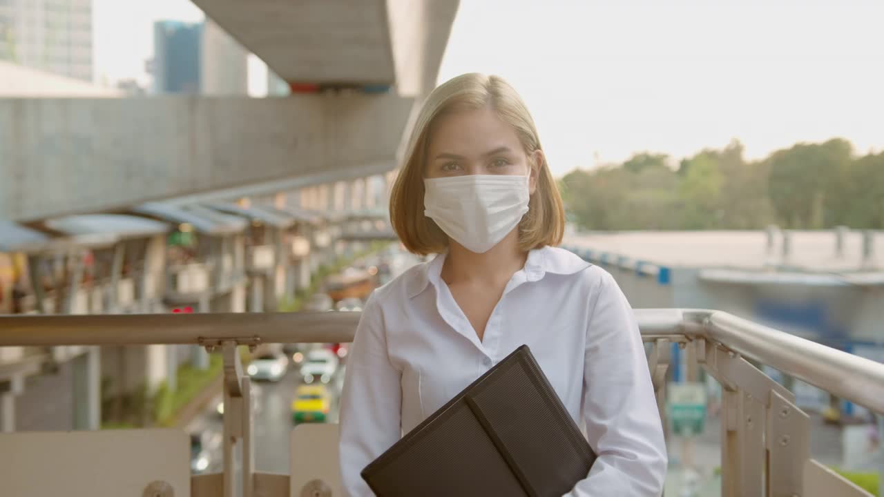一名年轻女子戴着防护口罩在地铁站台、新冠肺炎防护、安全运输、疫情防控理念下出行视频下载