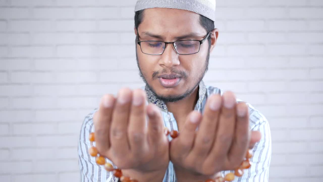 一名穆斯林男子在斋月期间用手做祈祷手势视频下载