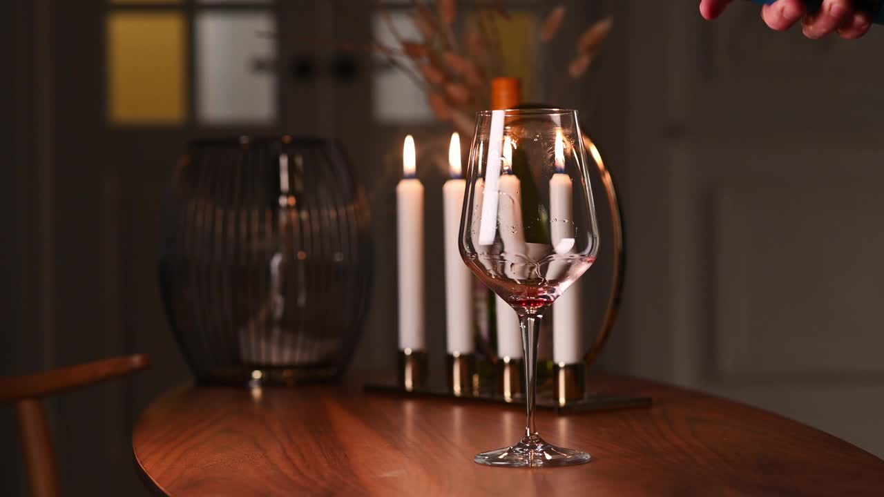 侍酒师在酒窖里品酒，他正在往玻璃杯里倒上一瓶极好的红酒。浪漫的晚餐视频下载