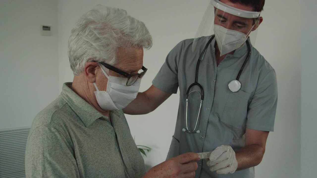 医生戴上防护口罩在家向年长男性病人讲解药物视频下载