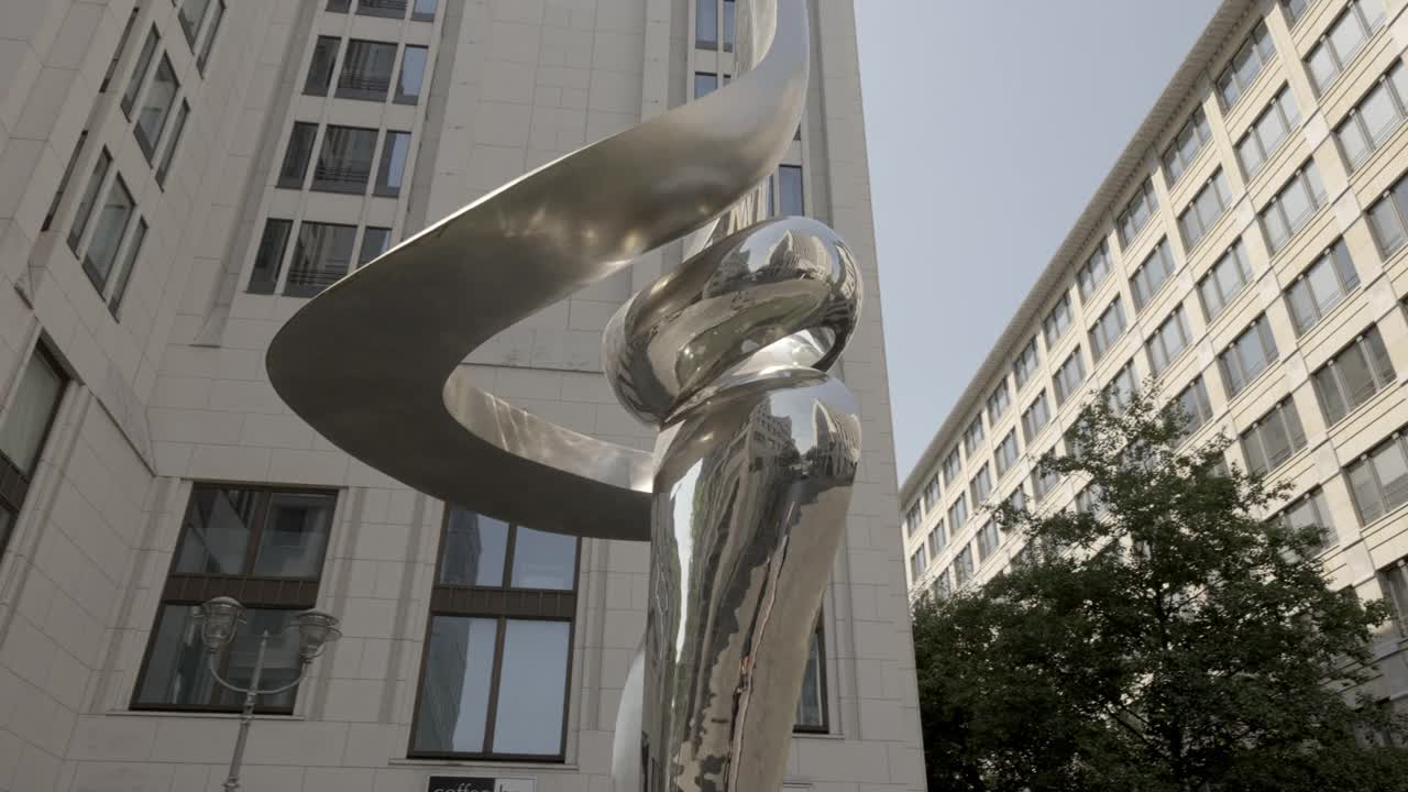 由金属制成的现代艺术雕塑，被高耸的高层建筑包围-柏林，德国视频下载